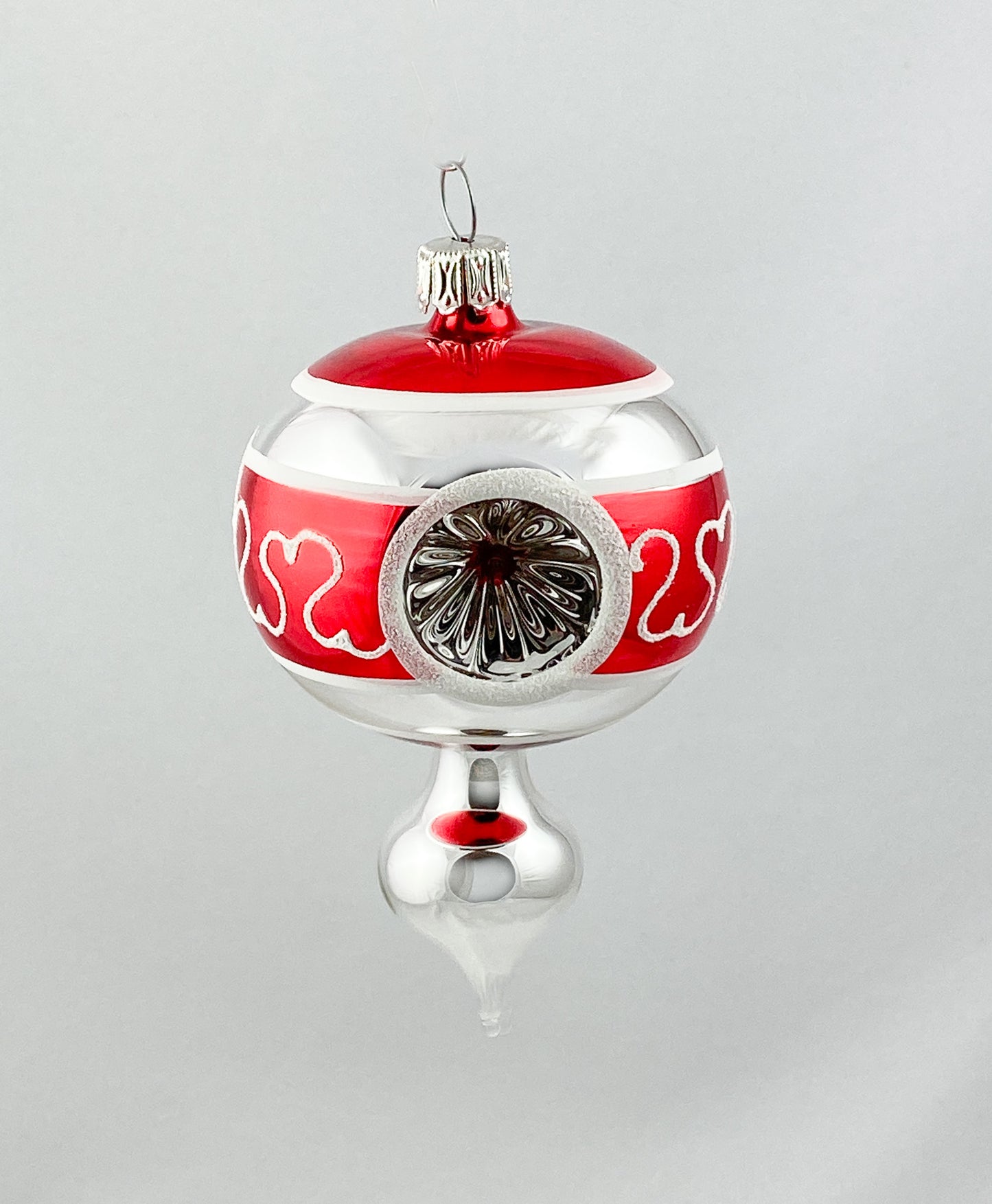 Kleines stilisiertes Zapfenmotiv mit drei Reflexen in Rot und Silber