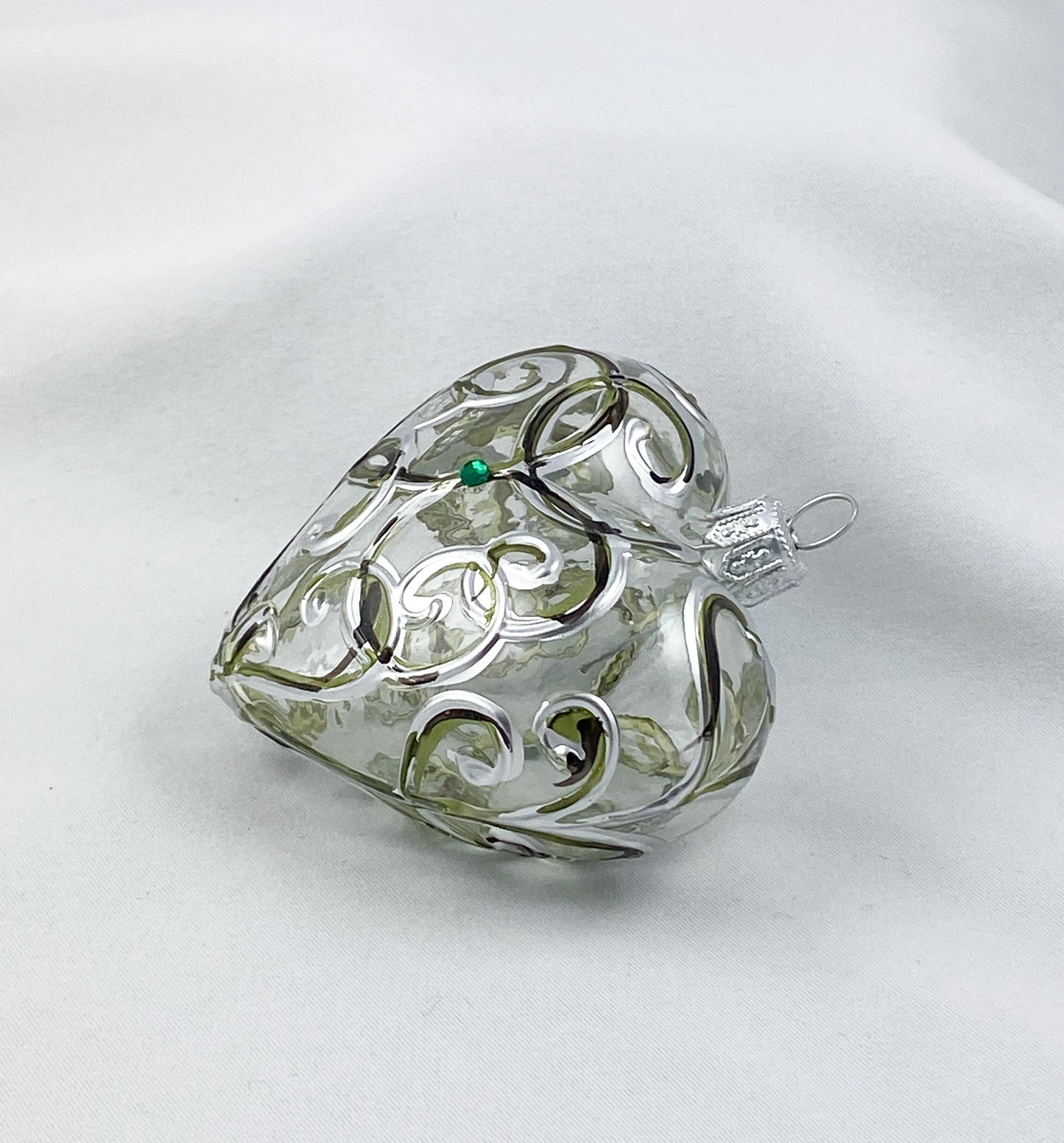 Transparentes Herz mit silbernen und grünen Kringeln