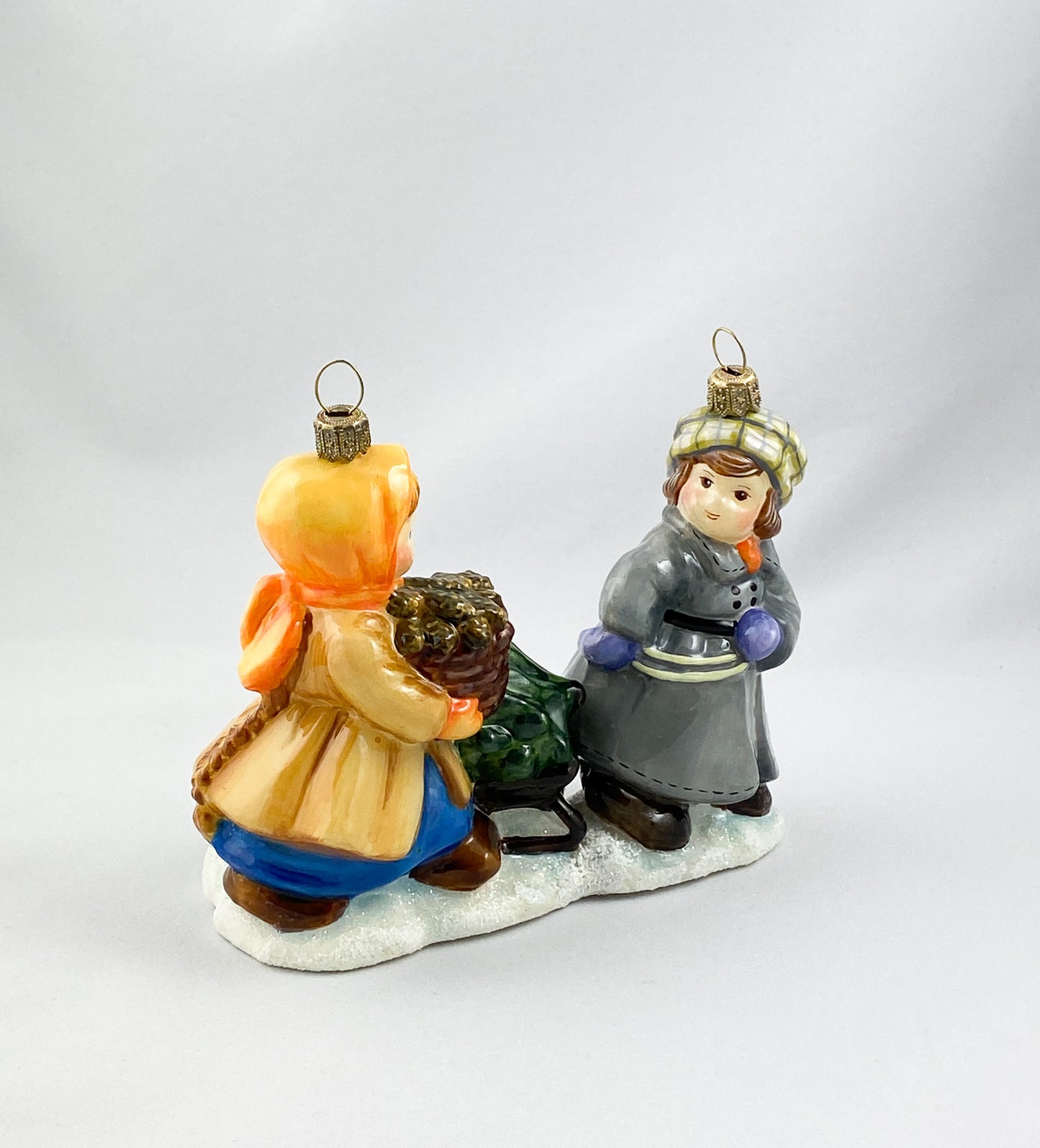 Das Mädchen und der Junge holen den Weihnachtsbaum mit dem Schlitten aus dem Wald, AtlasArt
