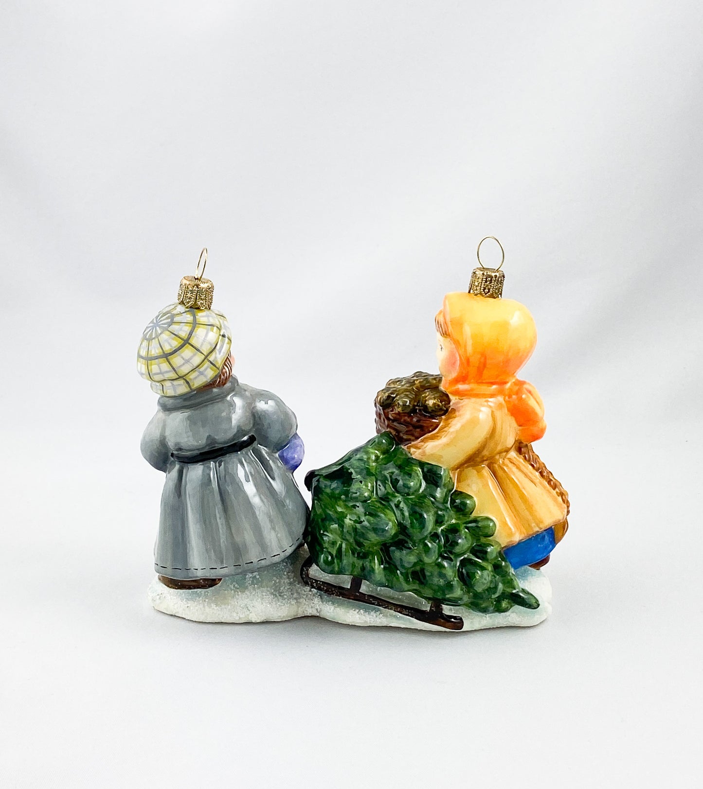 Das Mädchen und der Junge holen den Weihnachtsbaum mit dem Schlitten aus dem Wald, AtlasArt
