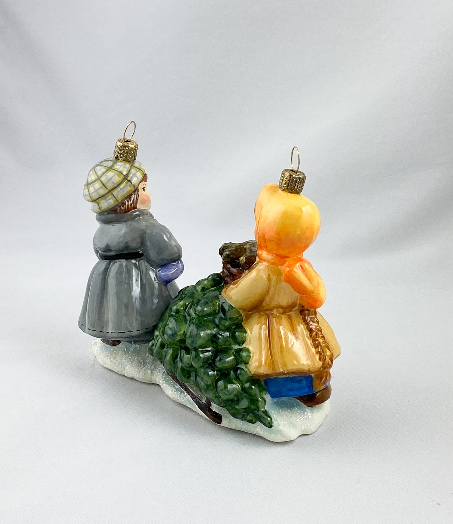 Das Mädchen und der Junge holen den Weihnachtsbaum mit dem Schlitten aus dem Wald, AtlasArt