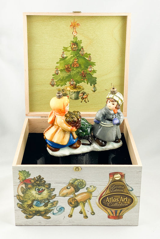 Das Mädchen und der Junge holen den Weihnachtsbaum mit dem Schlitten aus dem Wald, AtlasArt