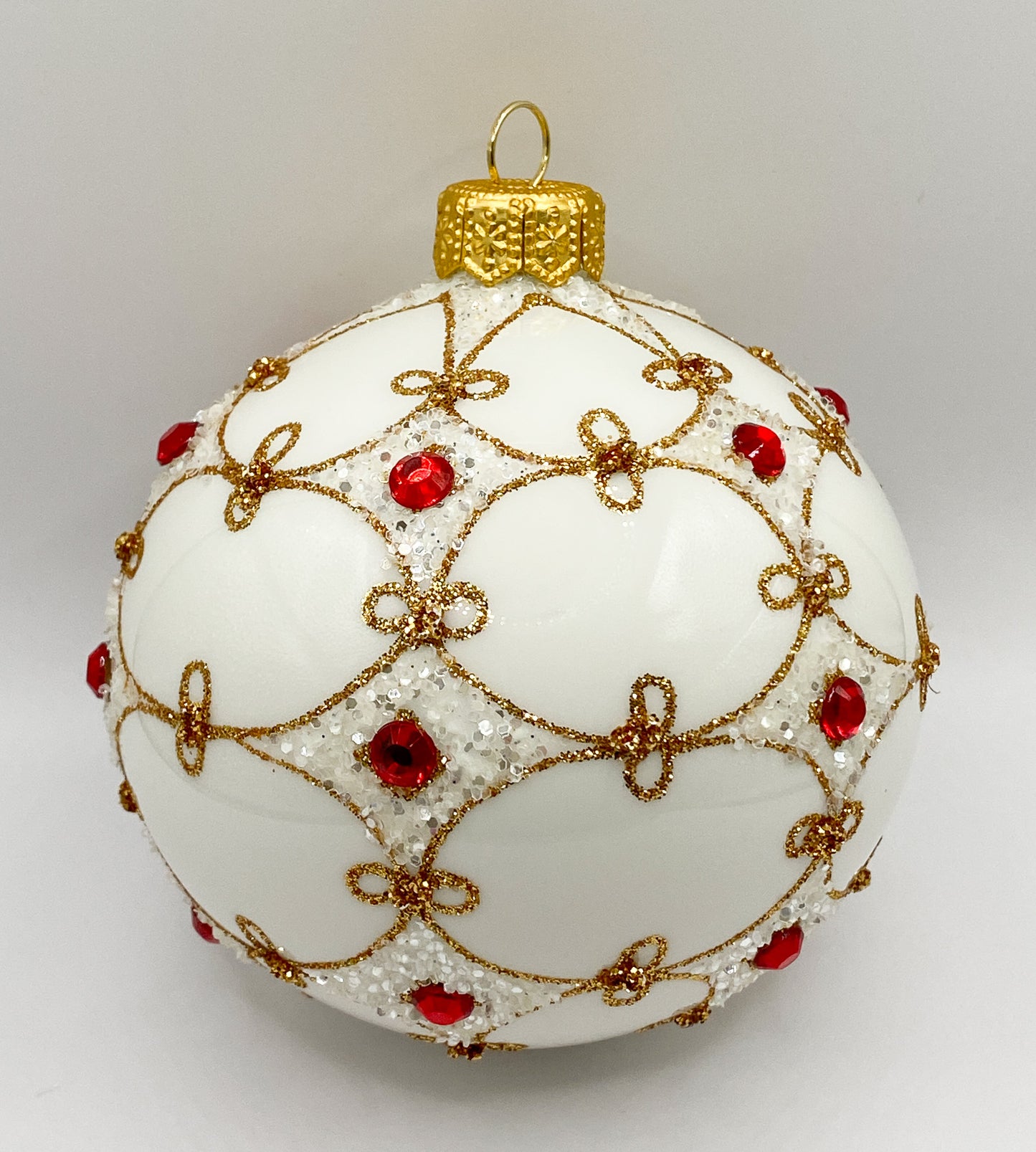 Weisse Kugel mit goldener Verzierung und roten Schmucksteinen