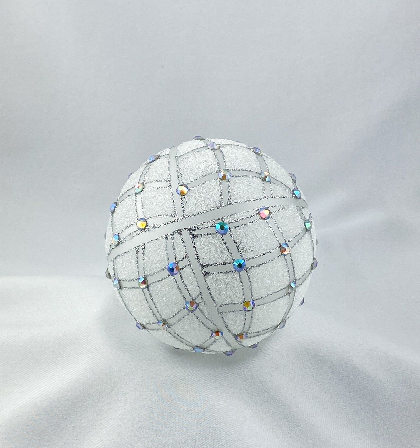 Kugel weiss transparent mit geometrischem Muster und irisierenden Schmucksteinen