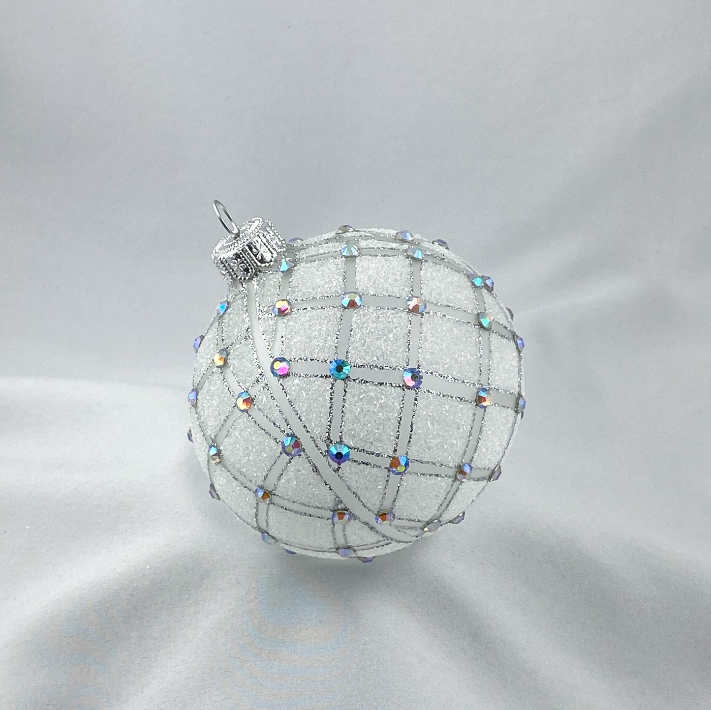 Kugel weiss transparent mit geometrischem Muster und irisierenden Schmucksteinen
