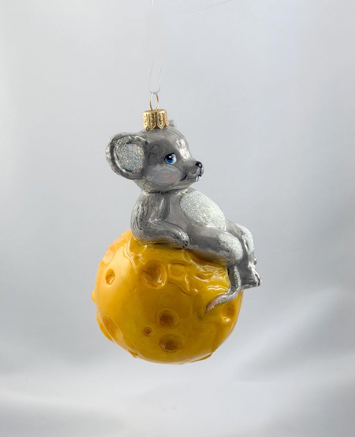 The mouse is sitting comfortably on the cheese globe