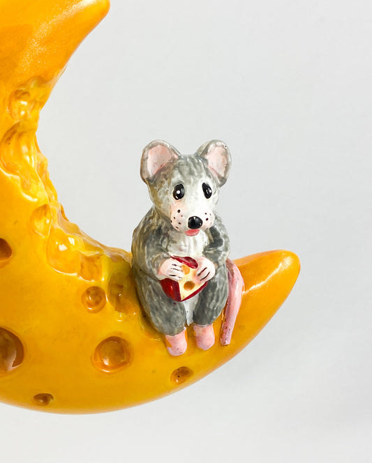 The mouse has made itself comfortable with a piece of cheese on the cheese crescent moon AtlasArt