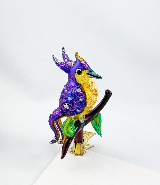 Violetter Paradiesvogel mit gelbem Bauch sitzt auf dem Zweig