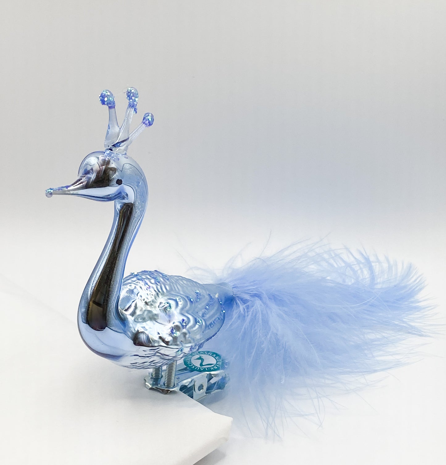 Large light blue peacock with crown and light blue down feathers
