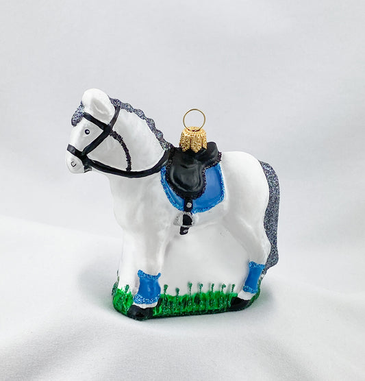 Weisses Pferd mit blauer Satteldecke