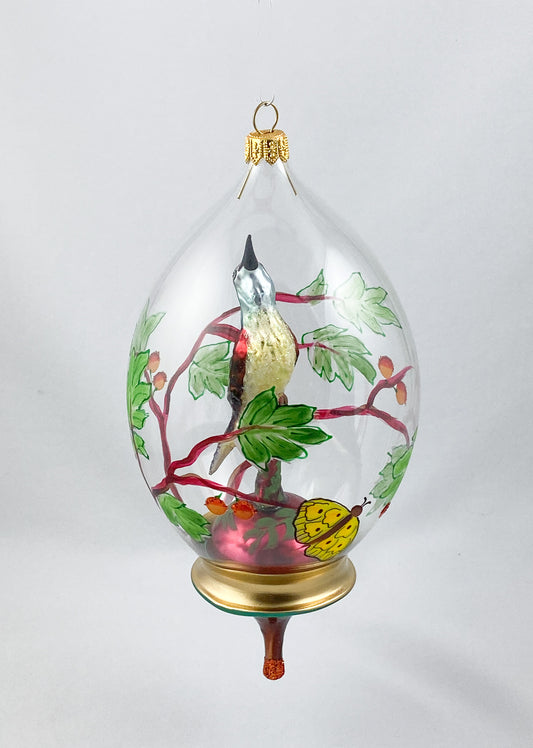 Singvogel in Kugel mit Schmetterling und Rankendekor