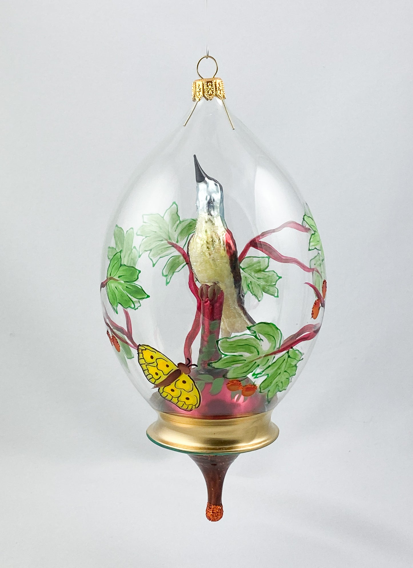 Singvogel in Kugel mit Schmetterling und Rankendekor