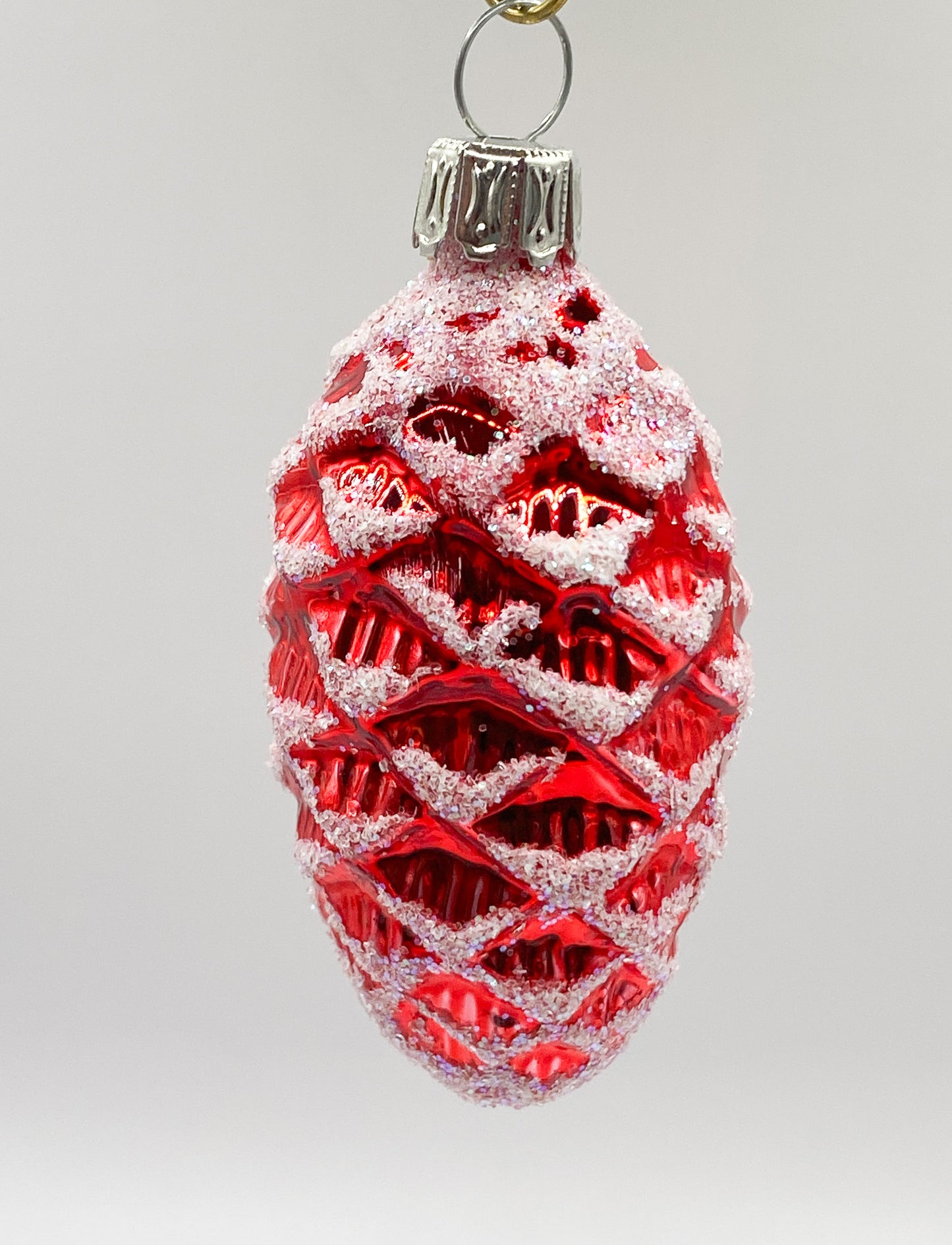 Small red shiny fir cone with white glitter