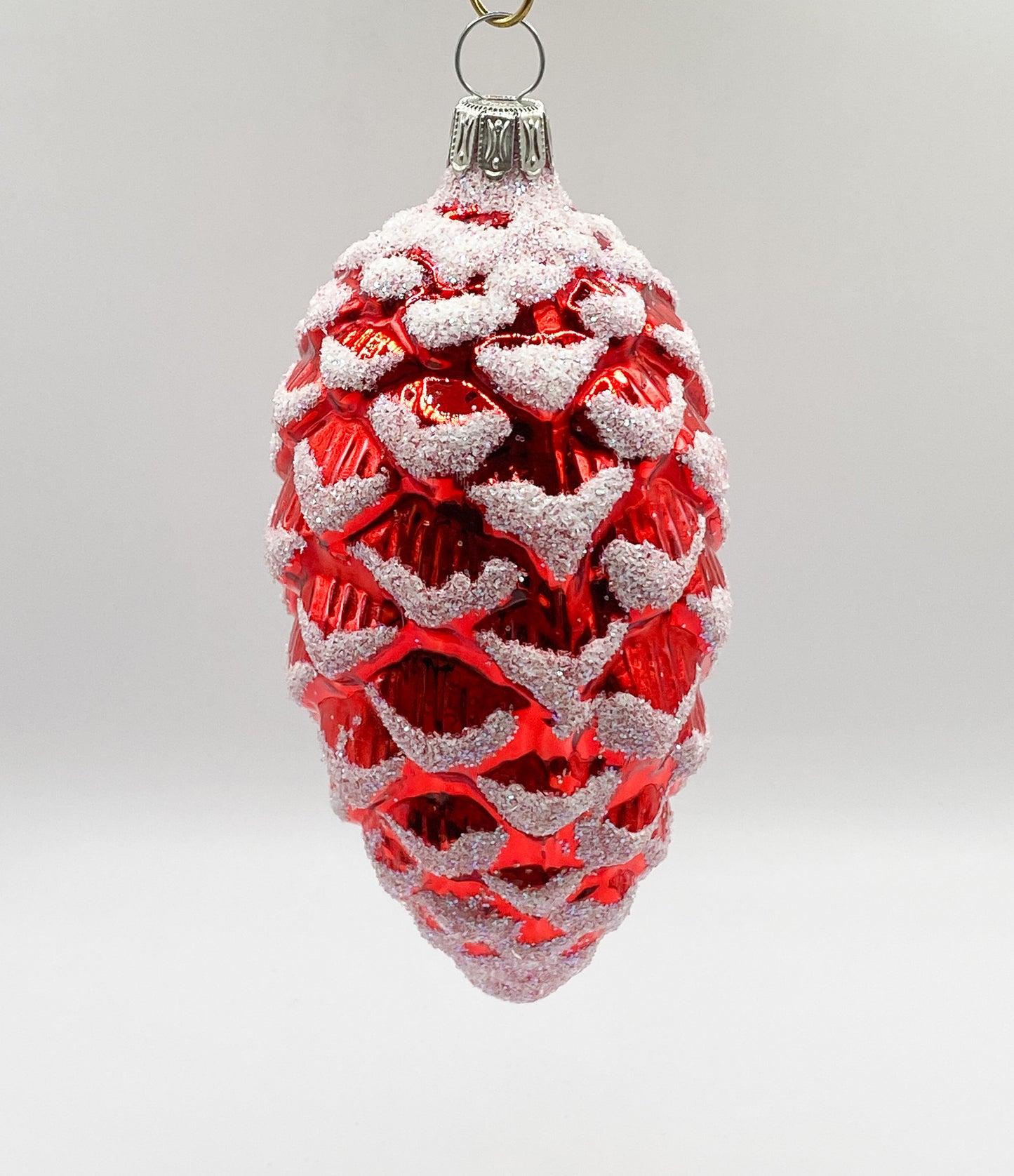 Red shiny fir cone with white glitter