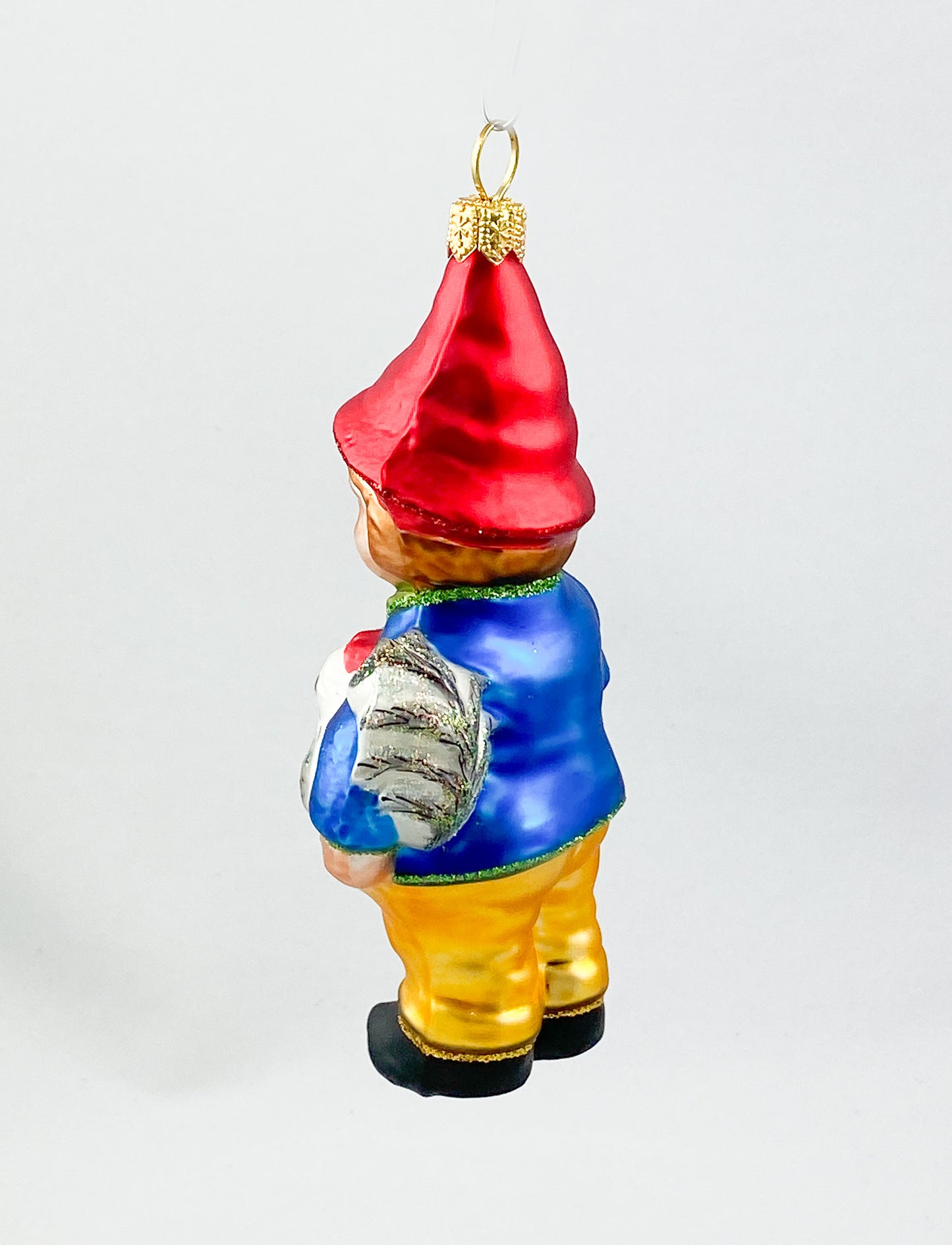 Zwerg in blauer Jacke mit Huhn unter dem Arm