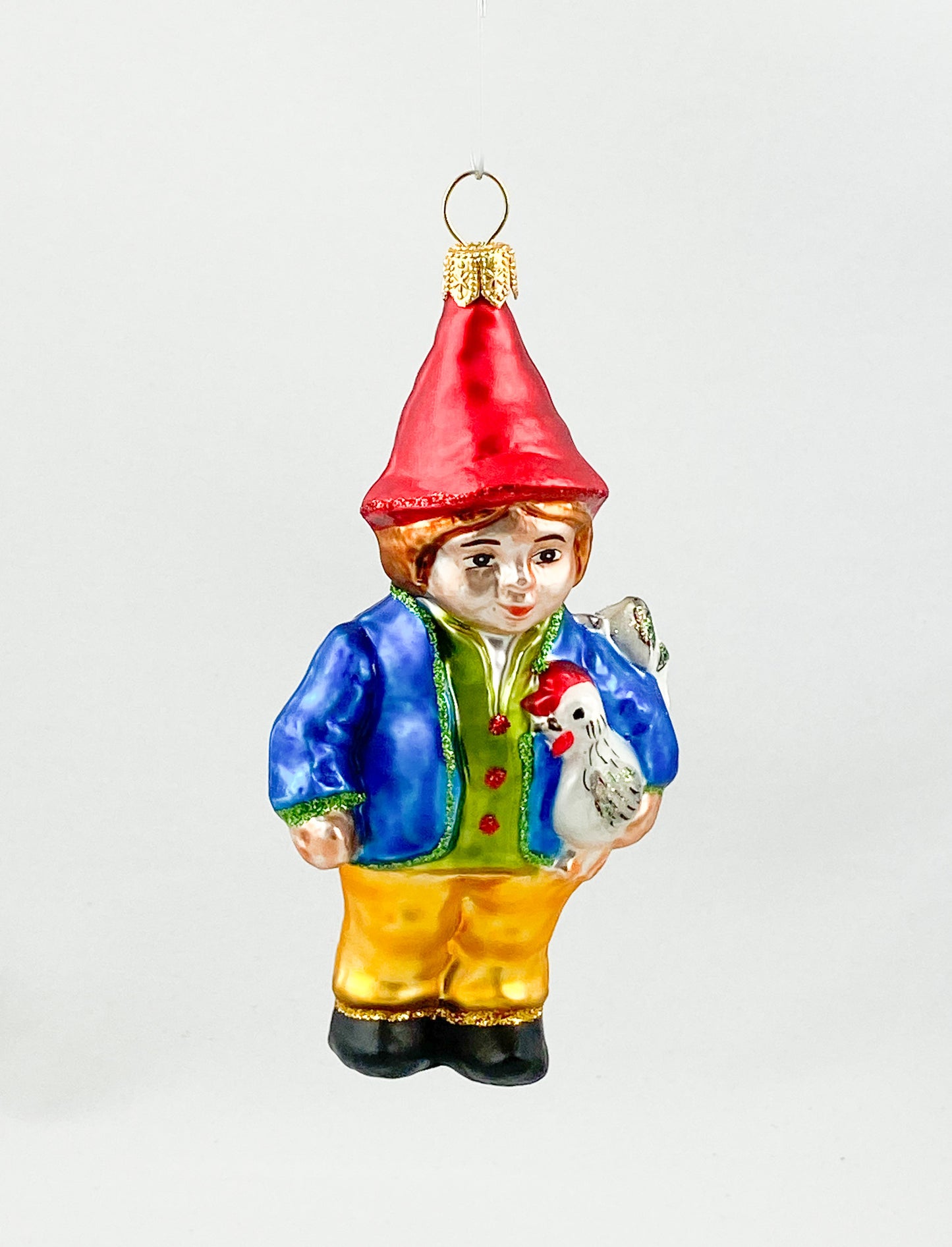 Zwerg in blauer Jacke mit Huhn unter dem Arm