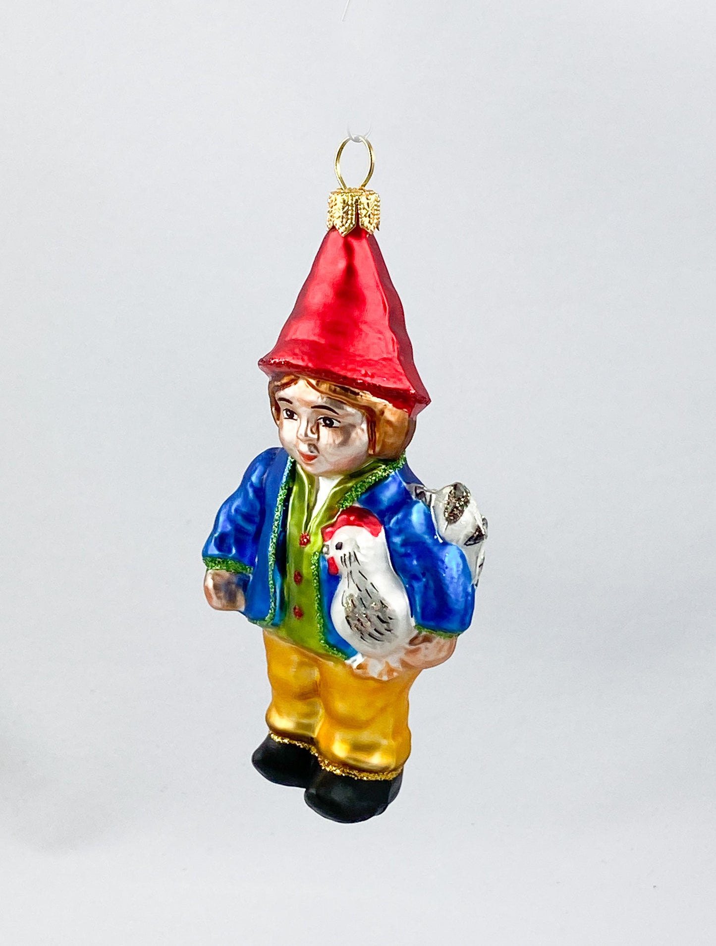 Zwerg in blauer Jacke mit Huhn unter dem Arm