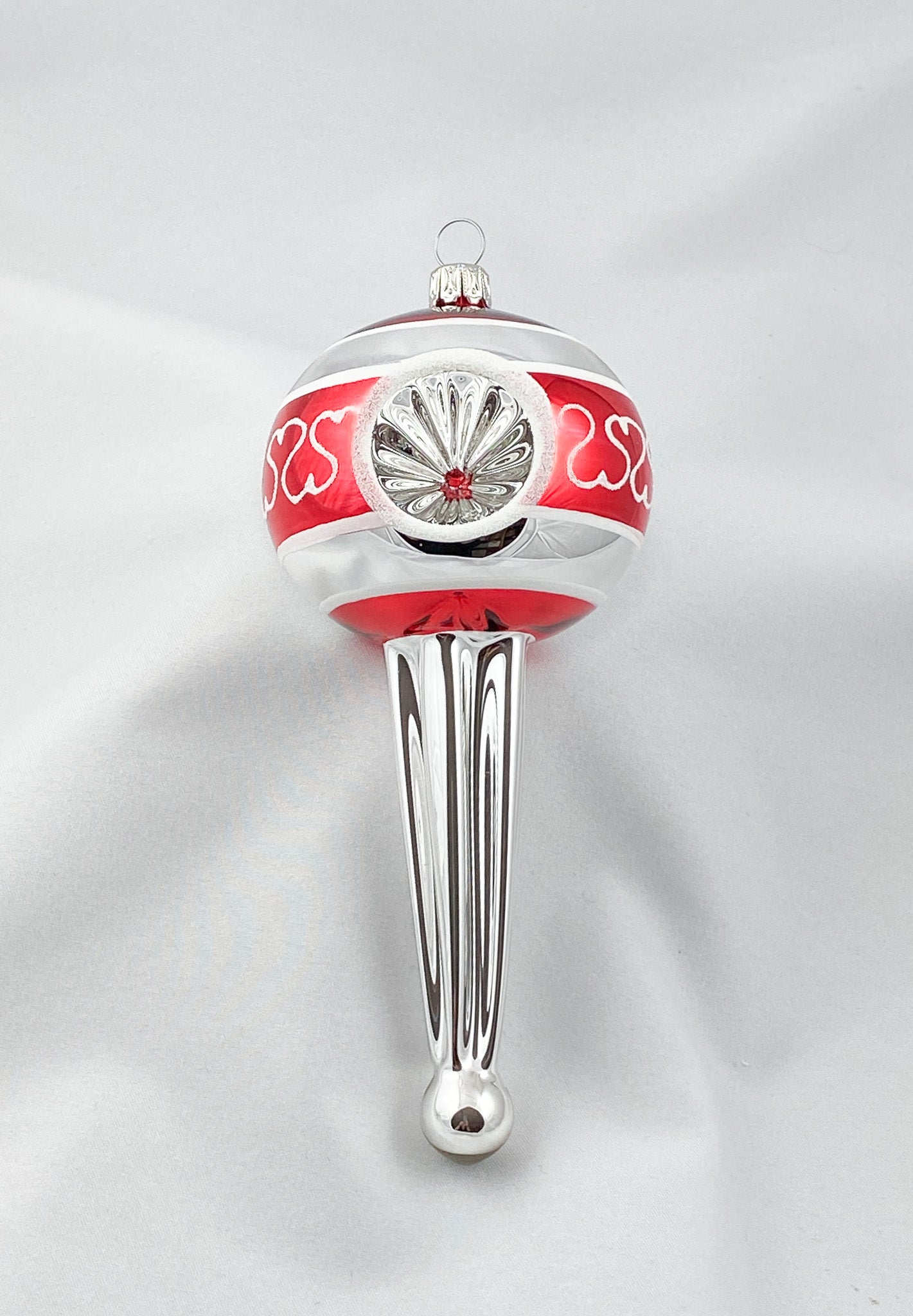 Stilisiertes Zapfenmotiv mit drei Reflexen in Rot und Silber