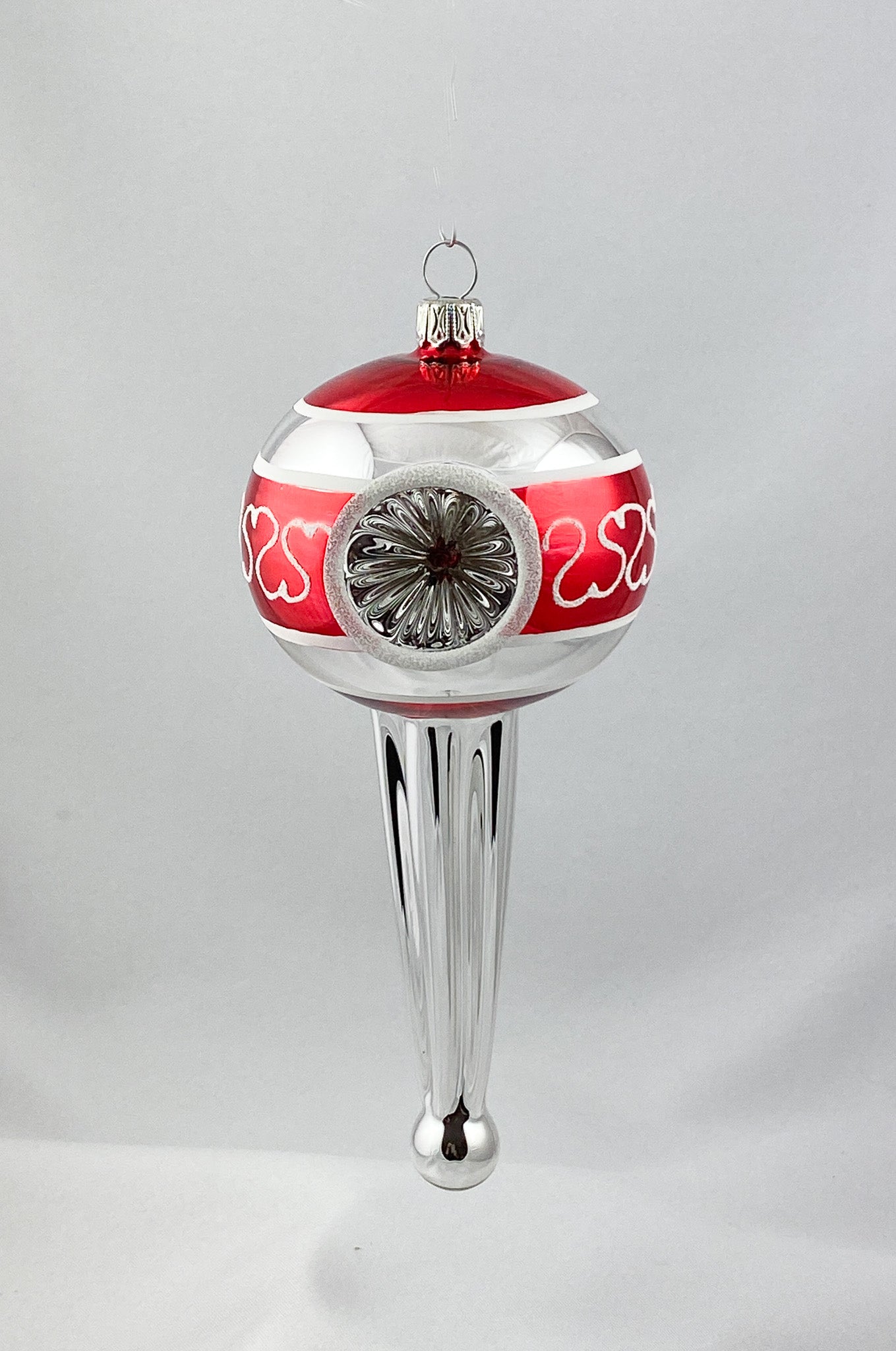 Stilisiertes Zapfenmotiv mit drei Reflexen in Rot und Silber