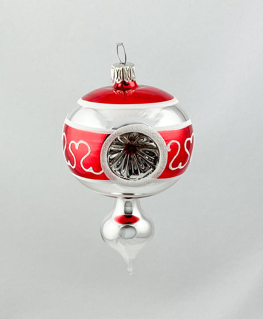 Kleines stilisiertes Zapfenmotiv mit drei Reflexen in Rot und Silber