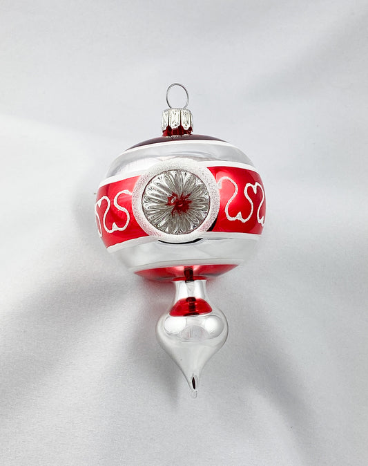 Kleines stilisiertes Zapfenmotiv mit drei Reflexen in Rot und Silber