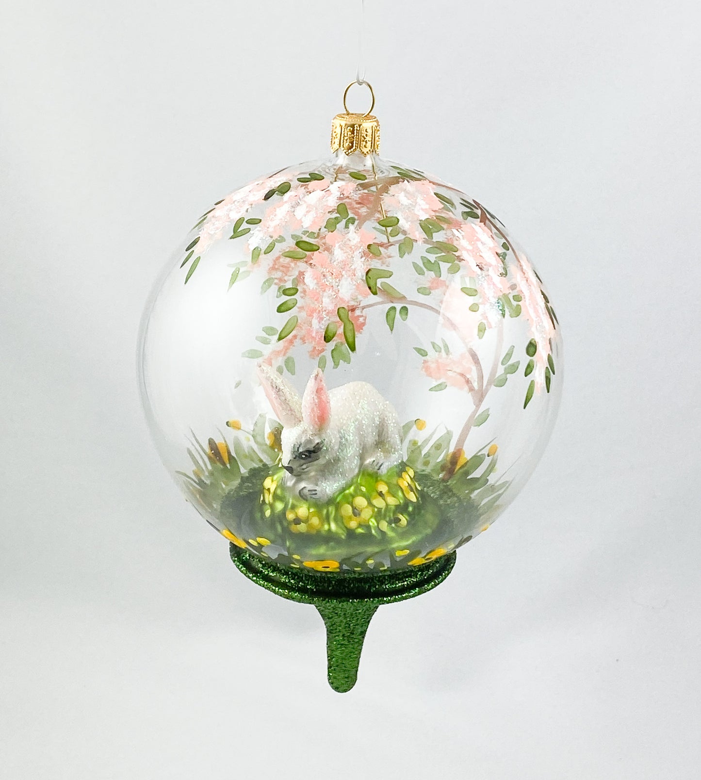 Weisser Hase unter dem blühendem Baum