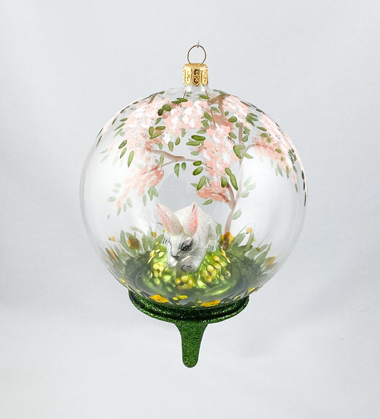 Weisser Hase unter dem blühendem Baum