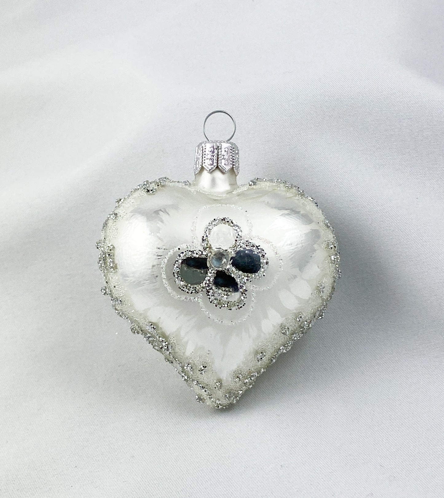 Silbernes Herz mit stilisierter Blüte
