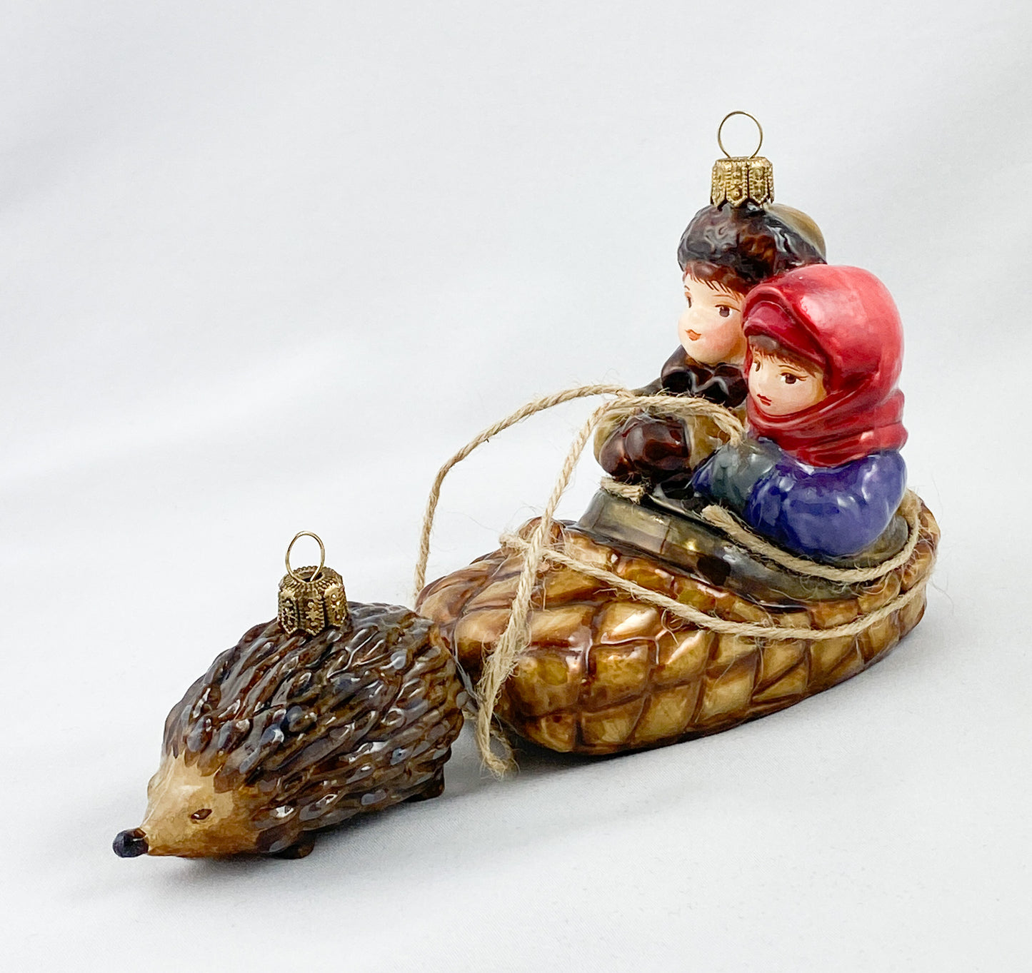 Two children in a hedgehog sleigh, set of 2, in a wooden box