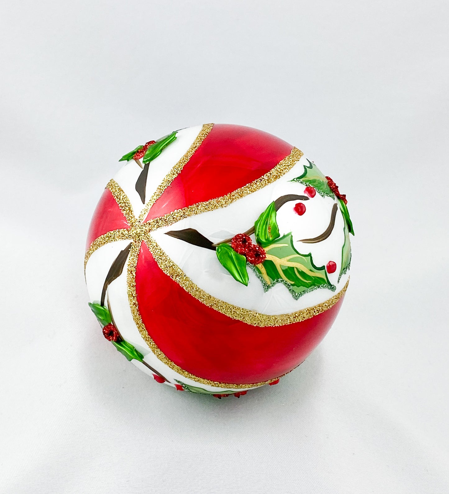 White red diagonally striped ball with holly decoration