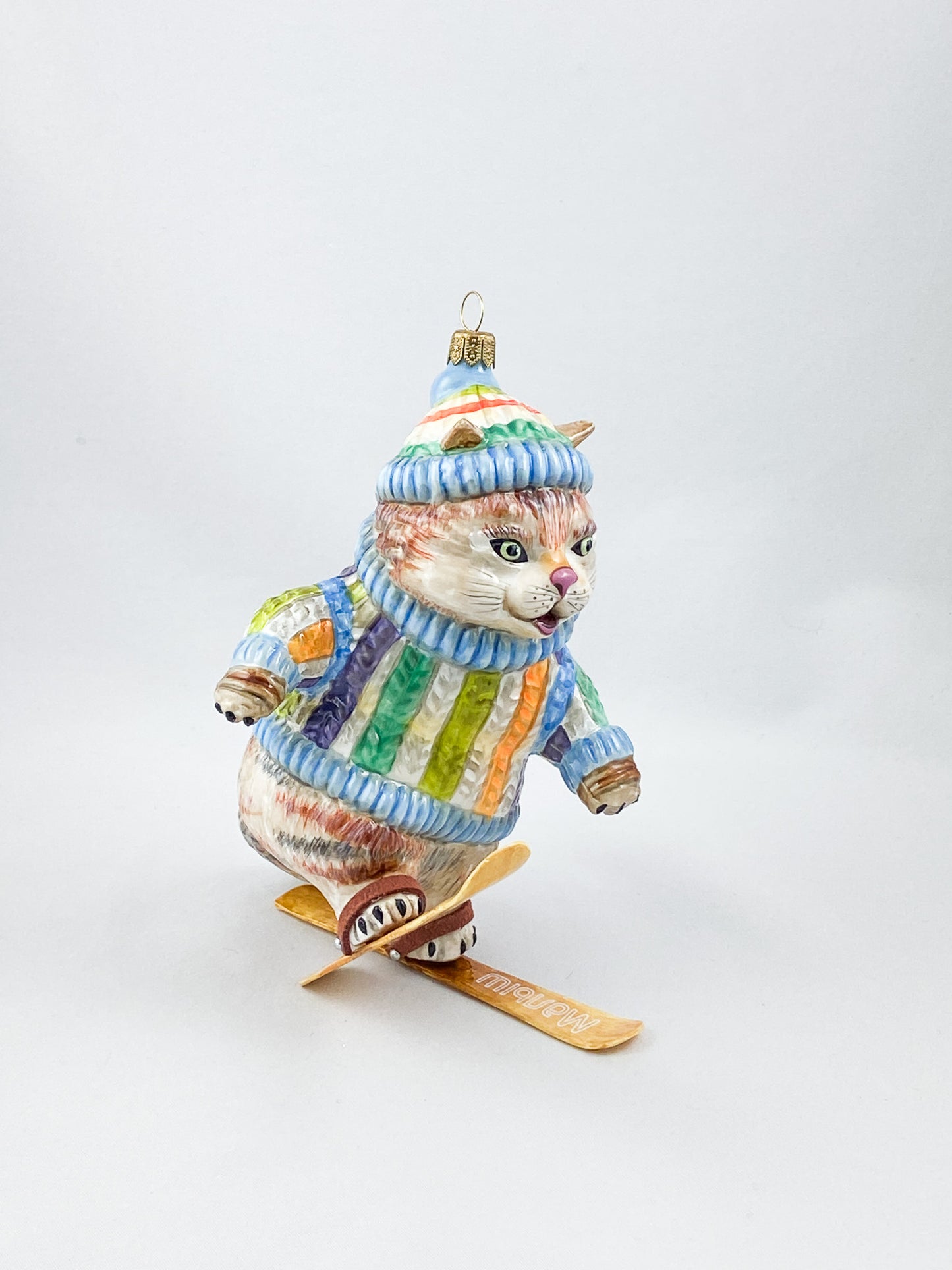 Die Katze im bunten Pullover versucht sich im Ski-Fahren ATLASART