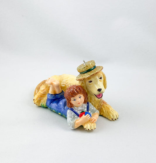 The girl is playing with the Golden Retriever in the summer meadow. AtlasArt