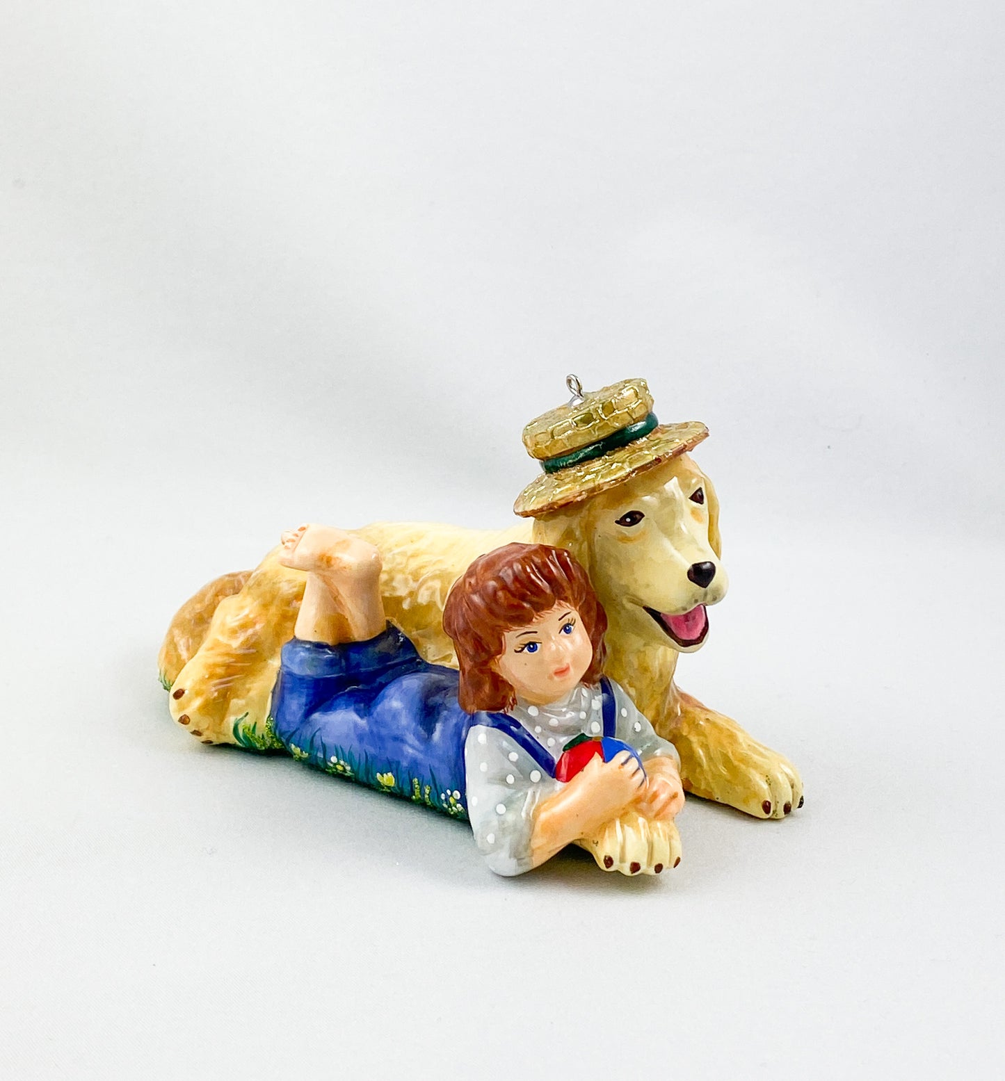 The girl is playing with the Golden Retriever in the summer meadow. AtlasArt