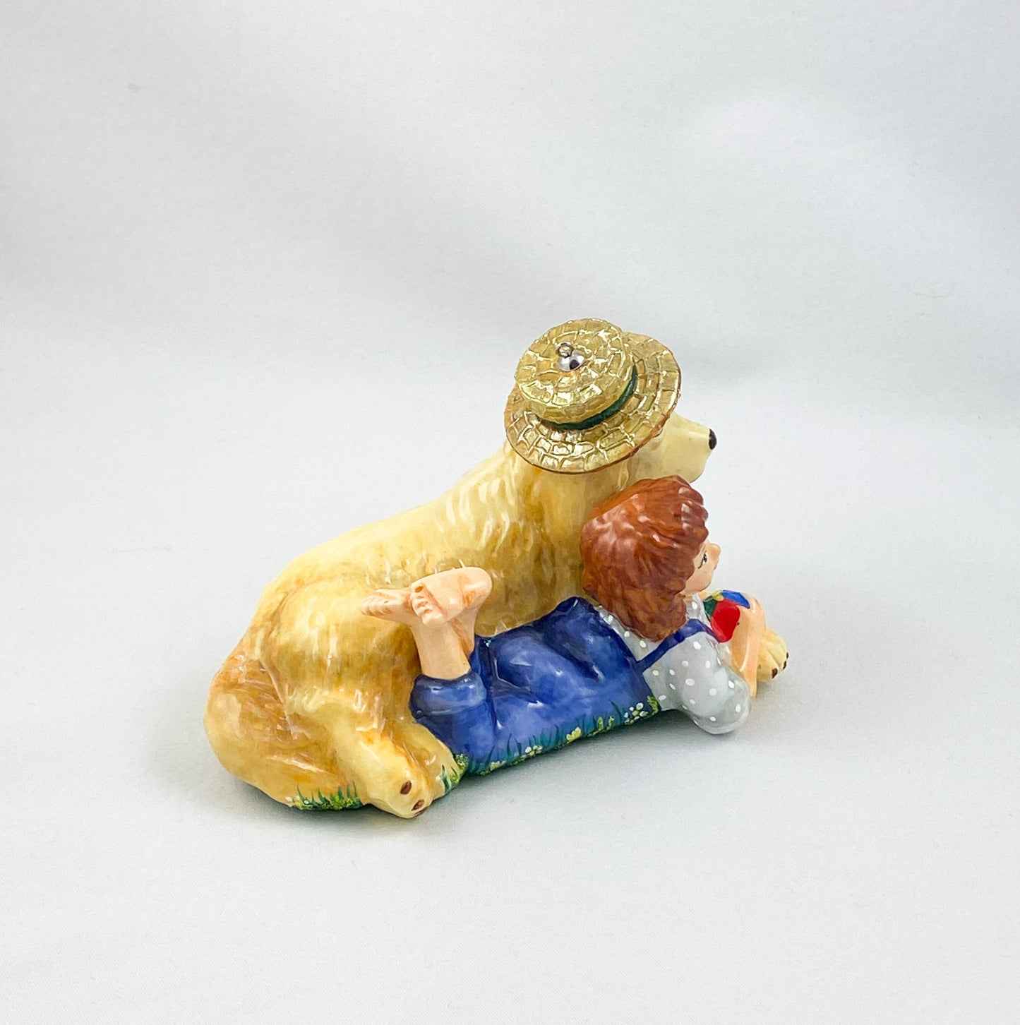 The girl is playing with the Golden Retriever in the summer meadow. AtlasArt