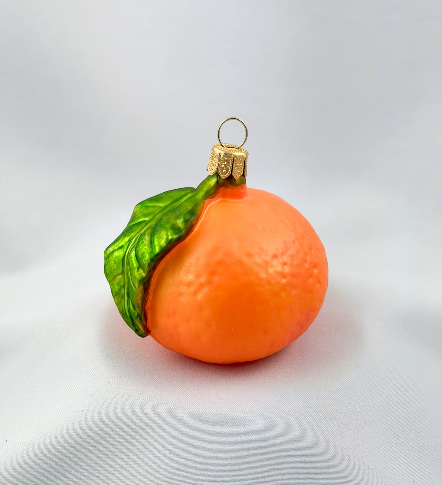 Mandarine mit grünem Blatt