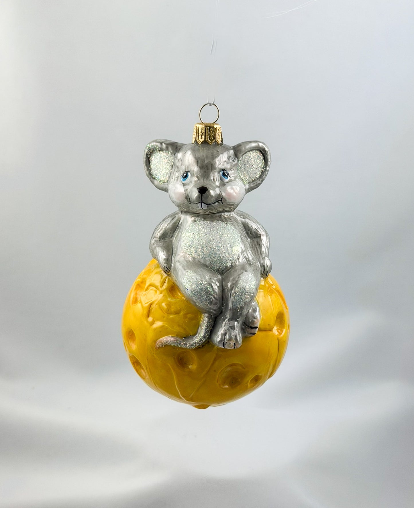 The mouse is sitting comfortably on the cheese globe
