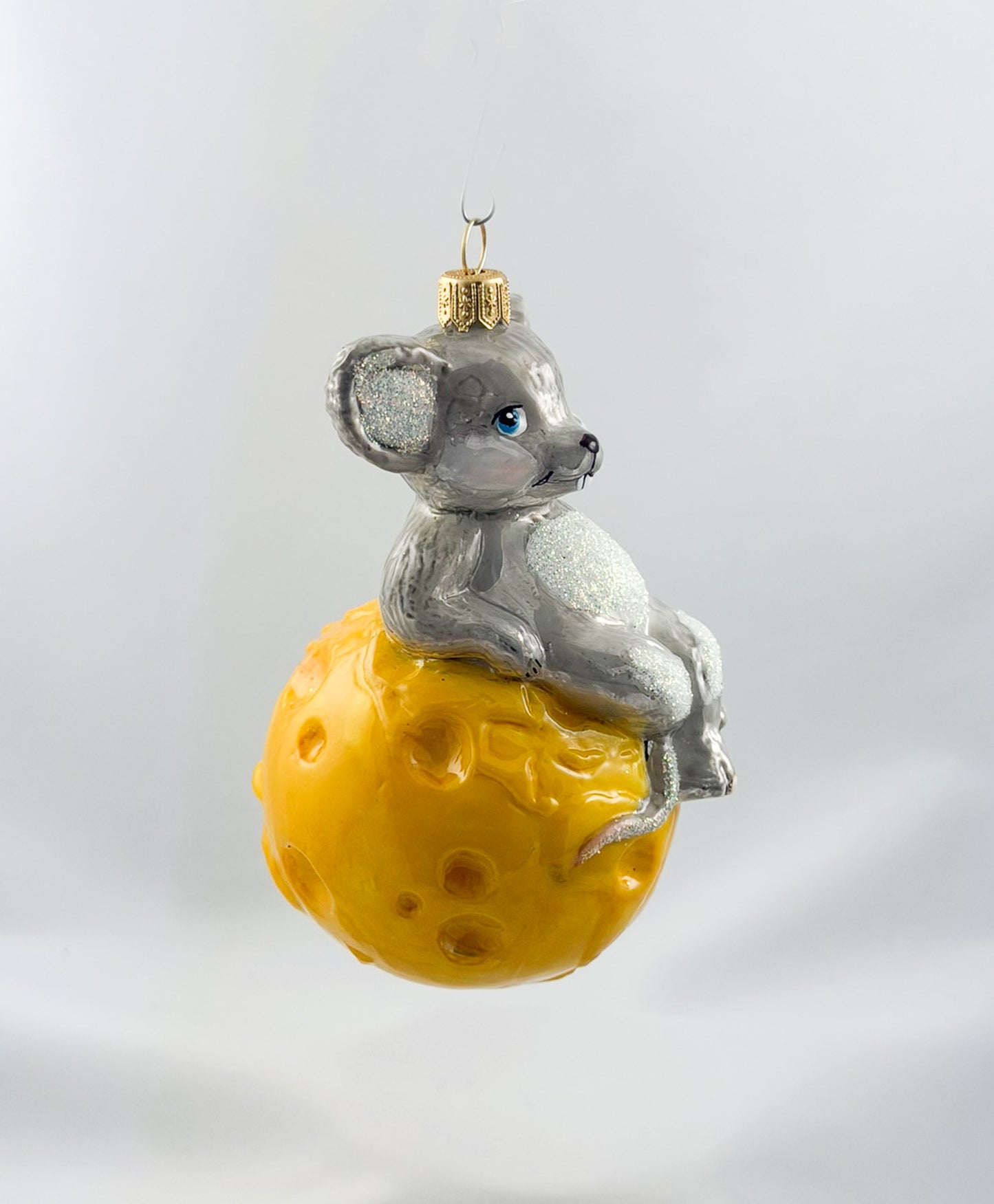 The mouse is sitting comfortably on the cheese globe