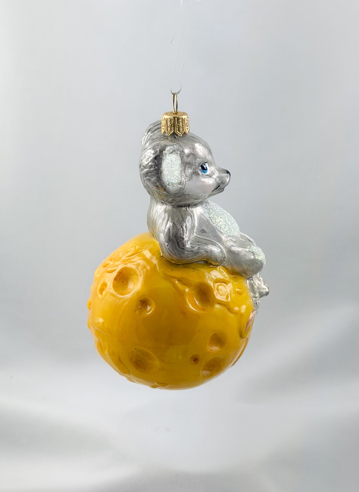 The mouse is sitting comfortably on the cheese globe