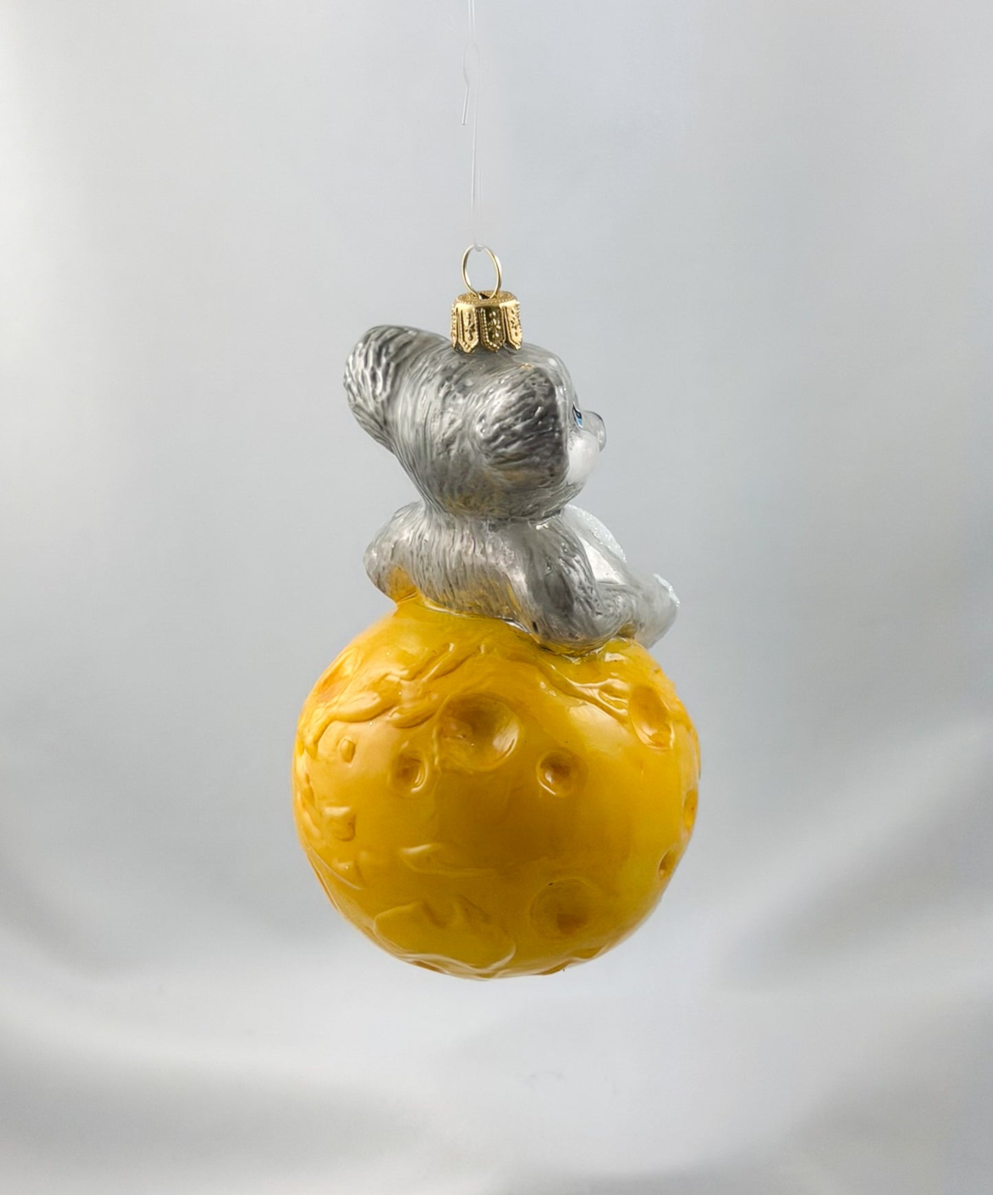 The mouse is sitting comfortably on the cheese globe