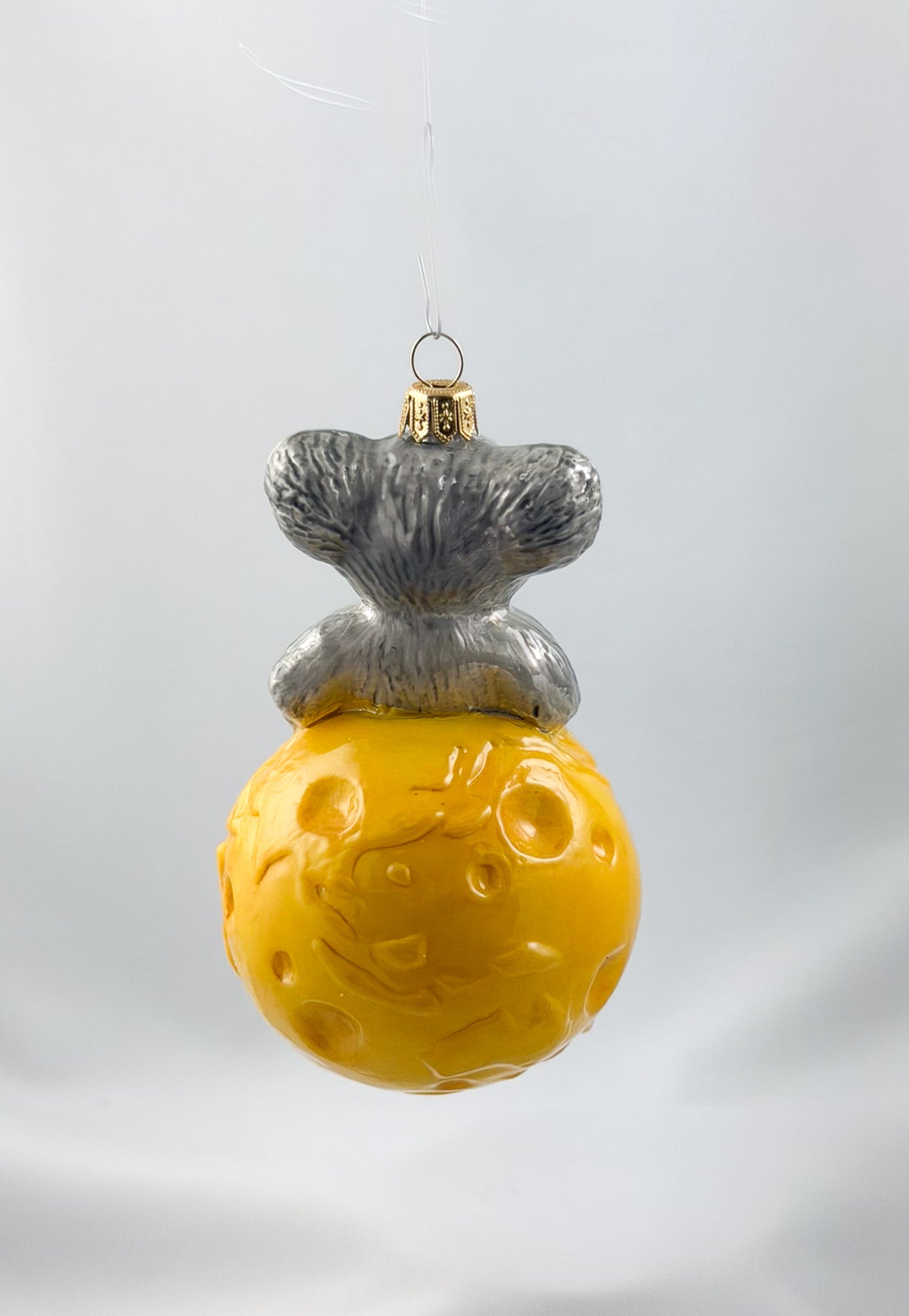 The mouse is sitting comfortably on the cheese globe