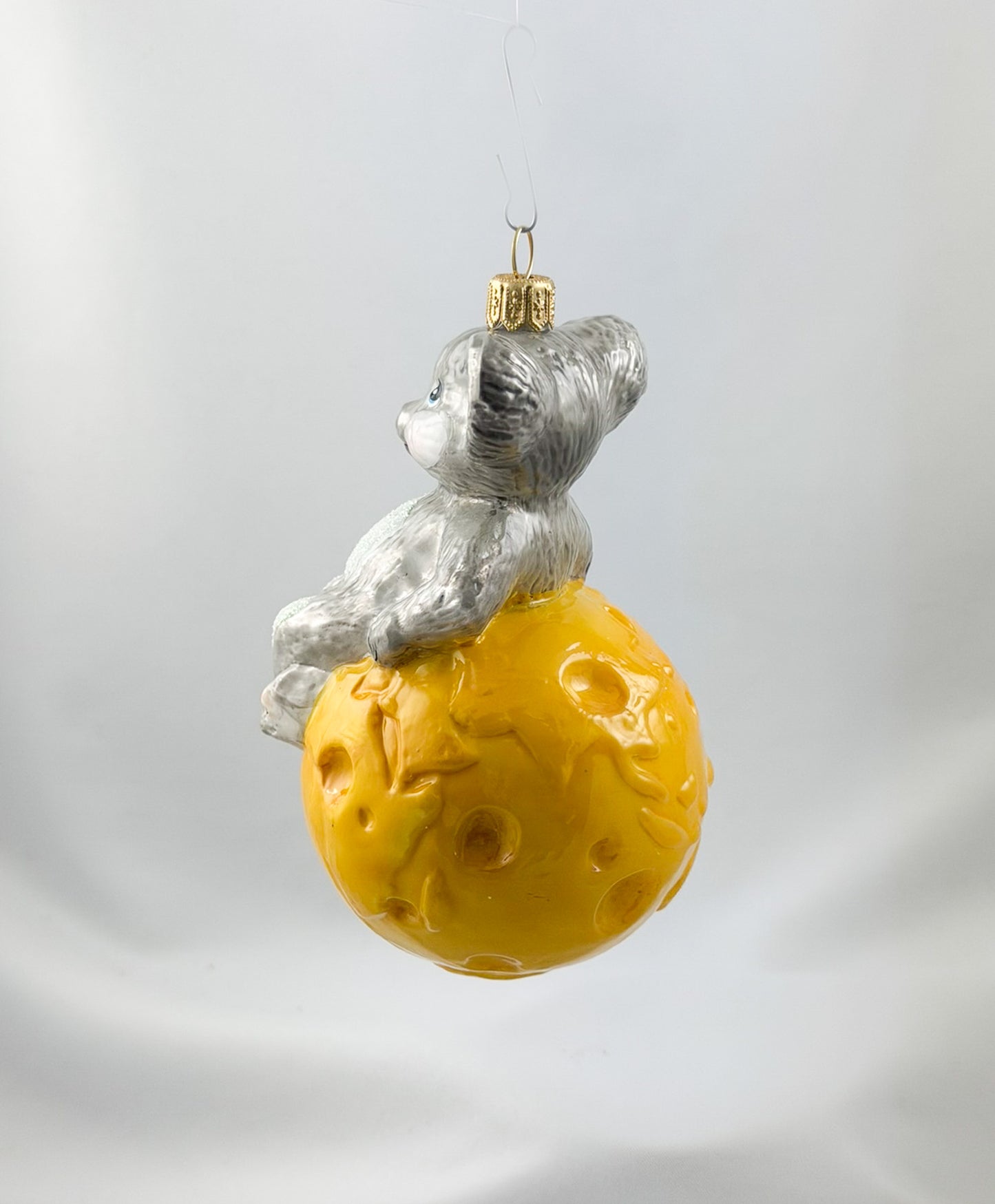 The mouse is sitting comfortably on the cheese globe
