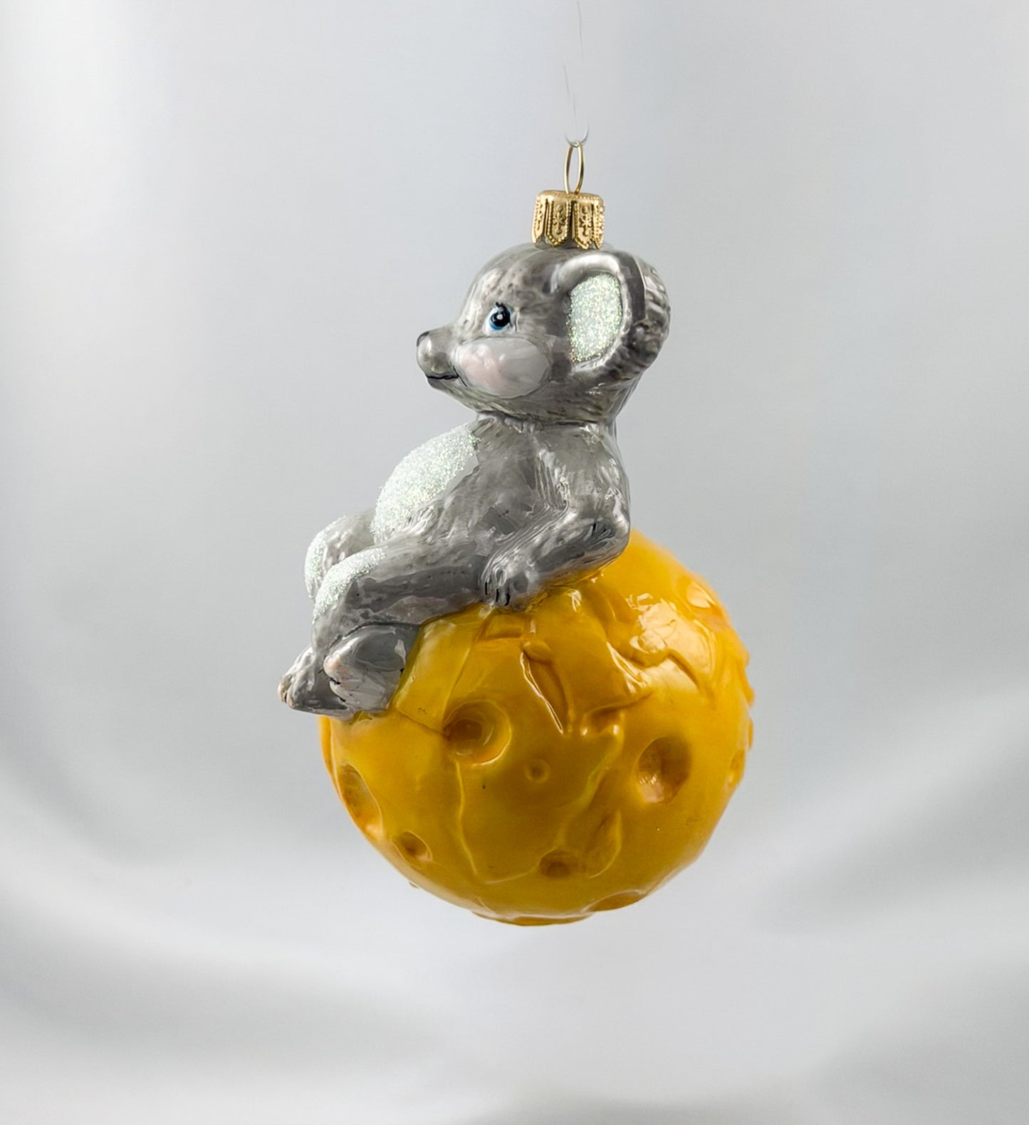 The mouse is sitting comfortably on the cheese globe