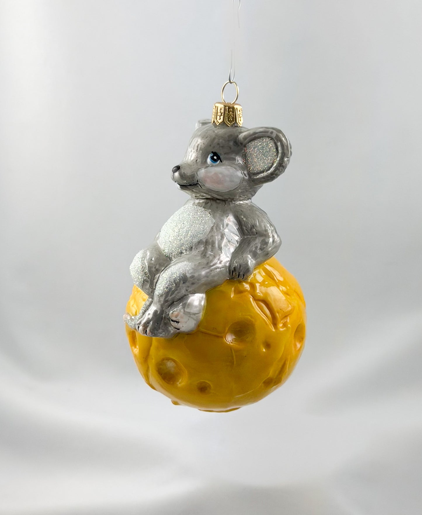 The mouse is sitting comfortably on the cheese globe