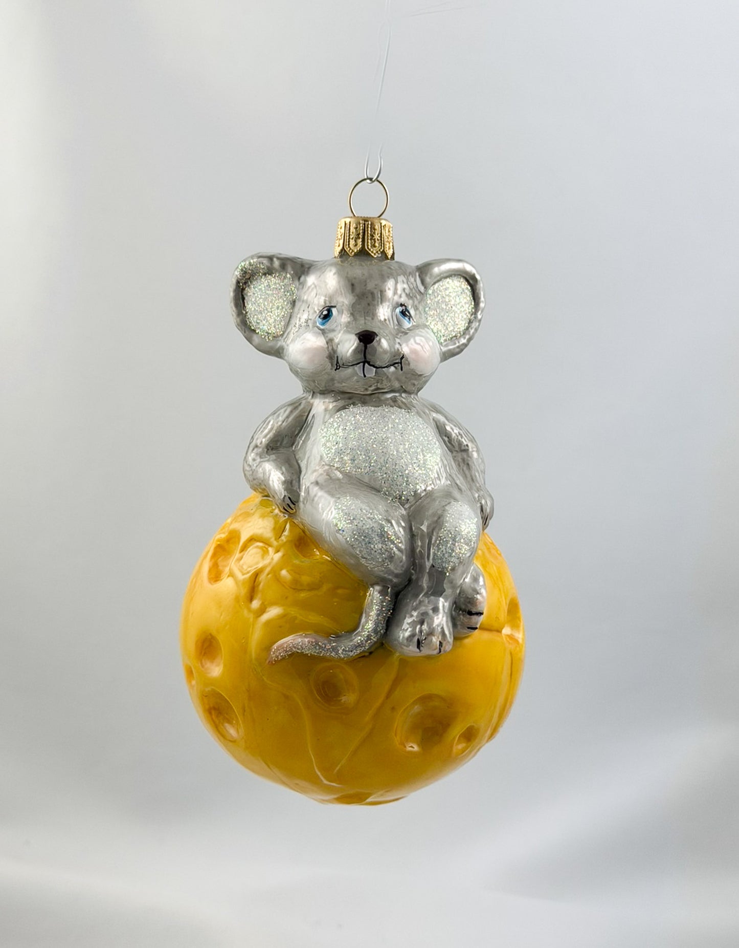 The mouse is sitting comfortably on the cheese globe