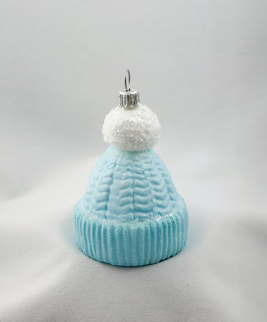 Light blue knitted hat with white pom-pom