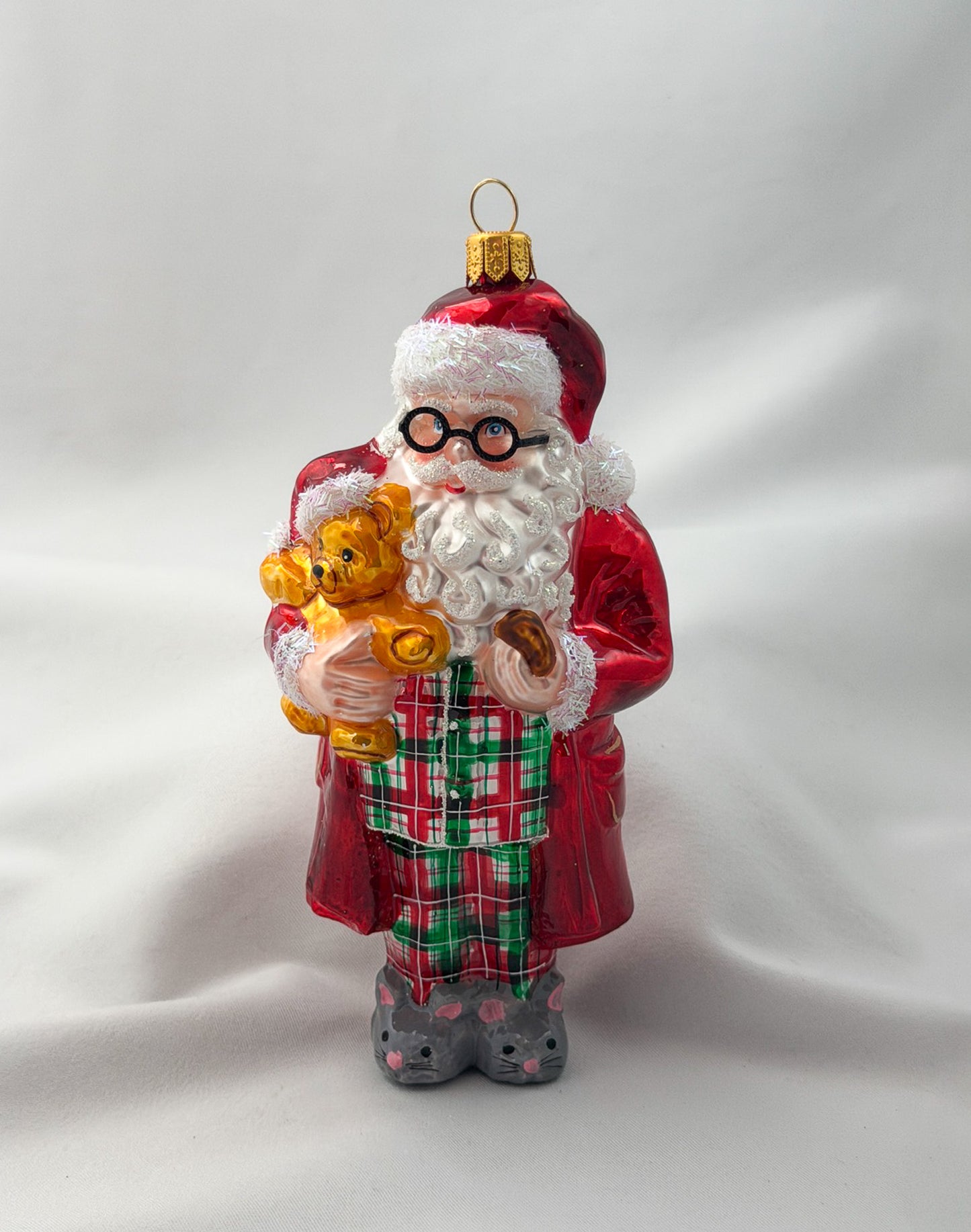 Santa has made himself comfortable with the teddy bear in mouse slippers and pajamas