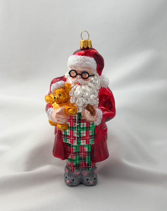 Santa has made himself comfortable with the teddy bear in mouse slippers and pajamas