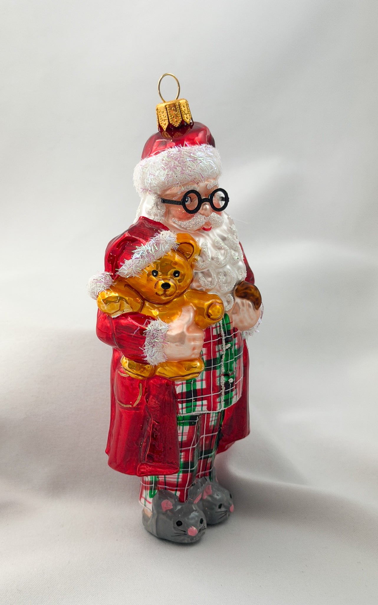 Santa has made himself comfortable with the teddy bear in mouse slippers and pajamas