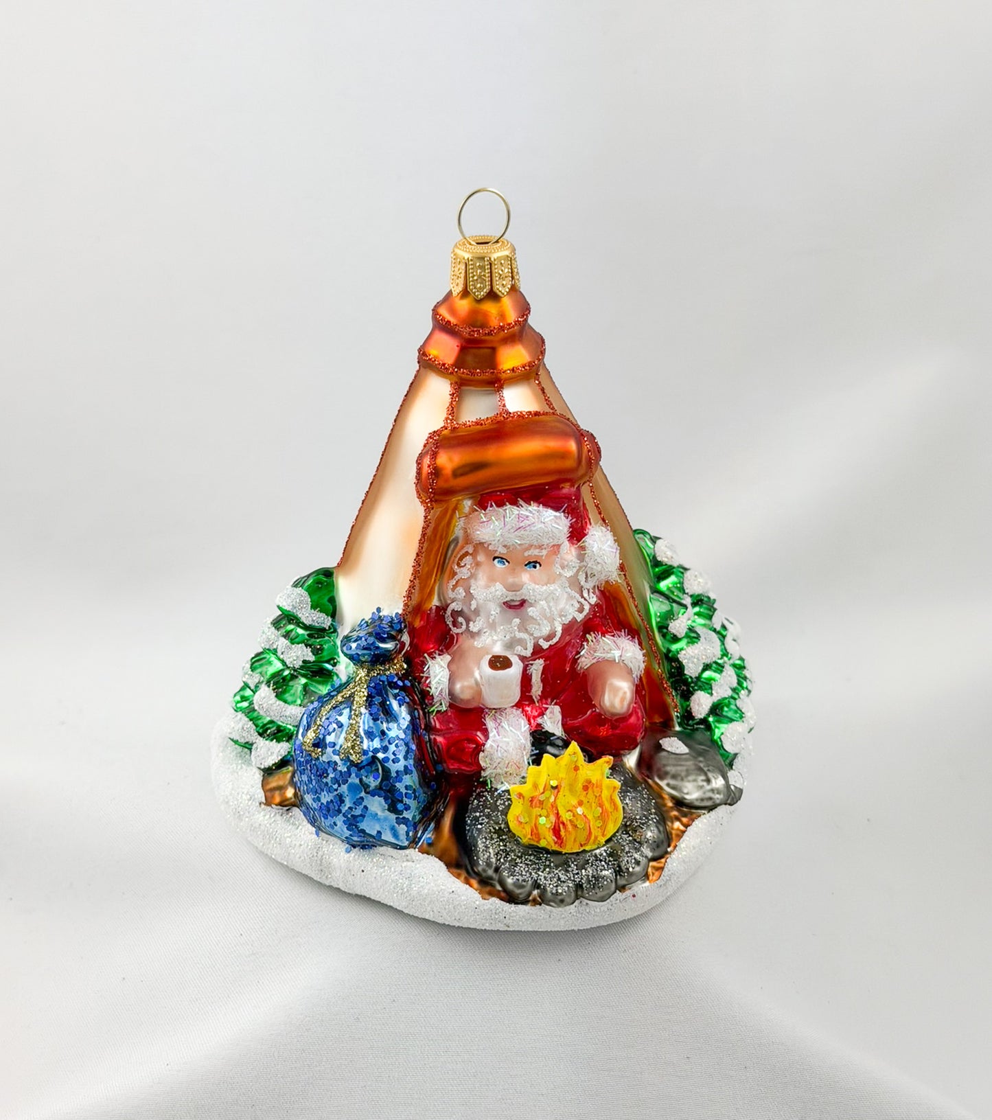 Santa is sitting comfortably in his tent by the campfire.