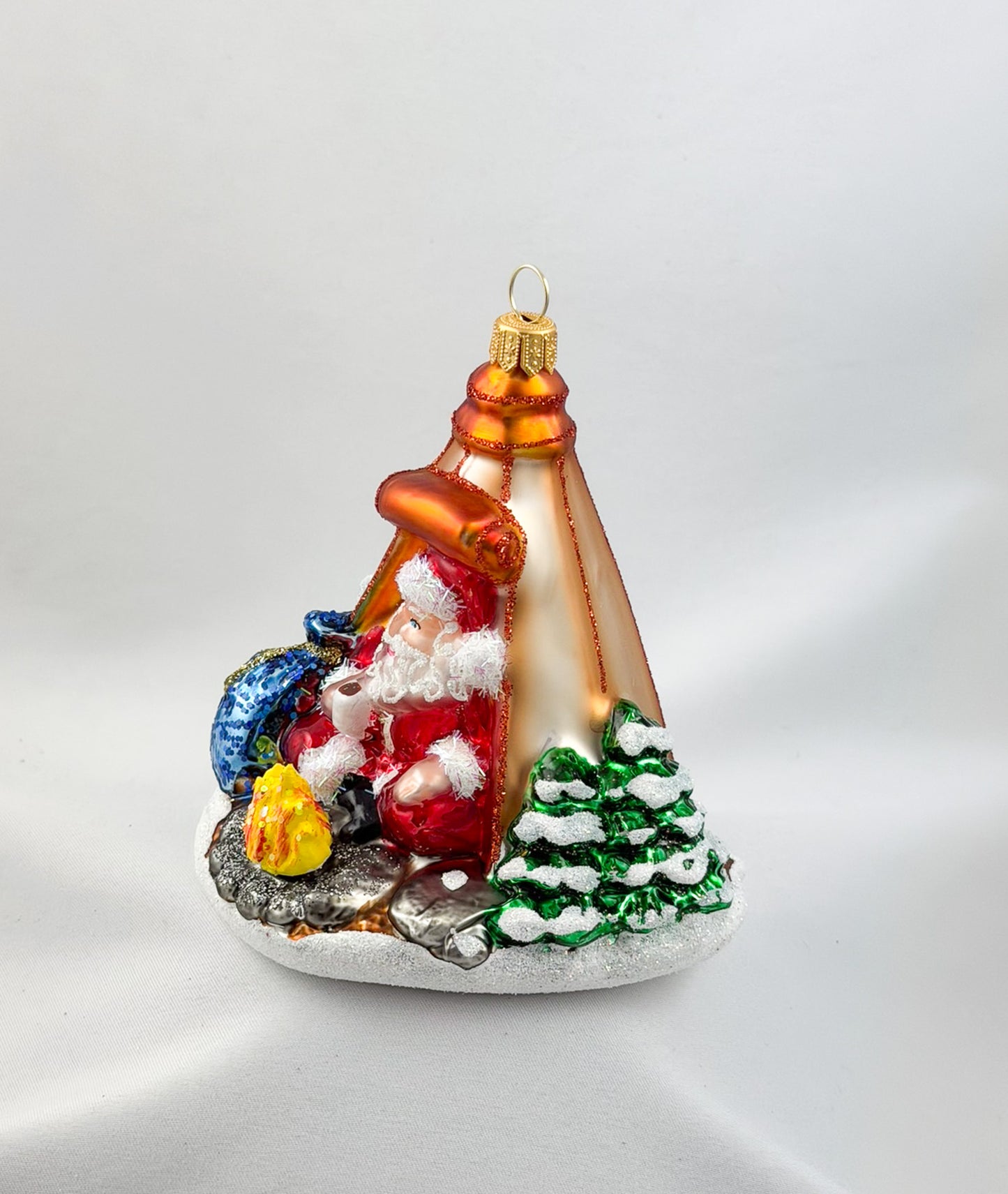 Santa is sitting comfortably in his tent by the campfire.